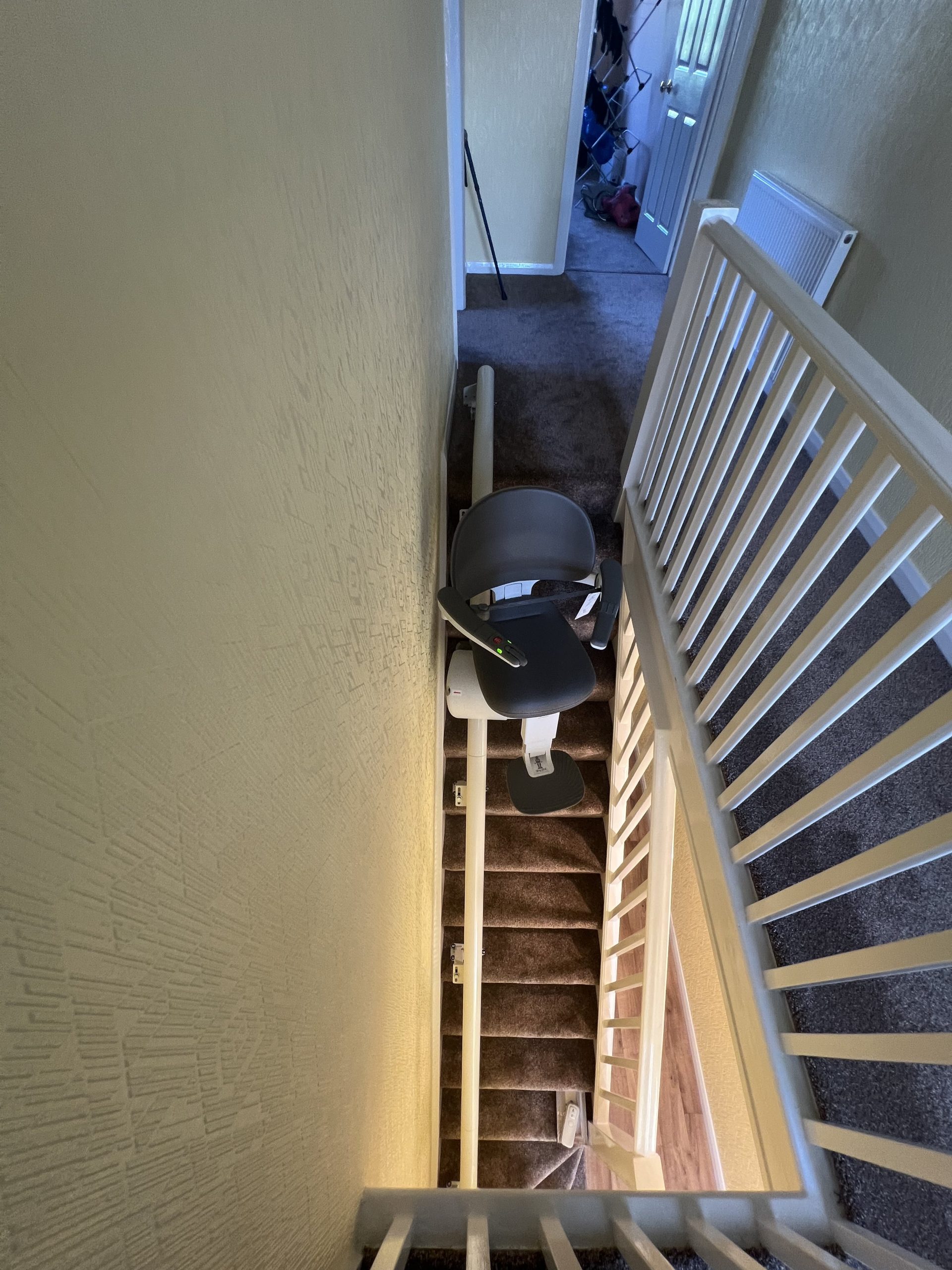 Flow X curved stairlift specialist example top view of seat travelling to top of stairs
