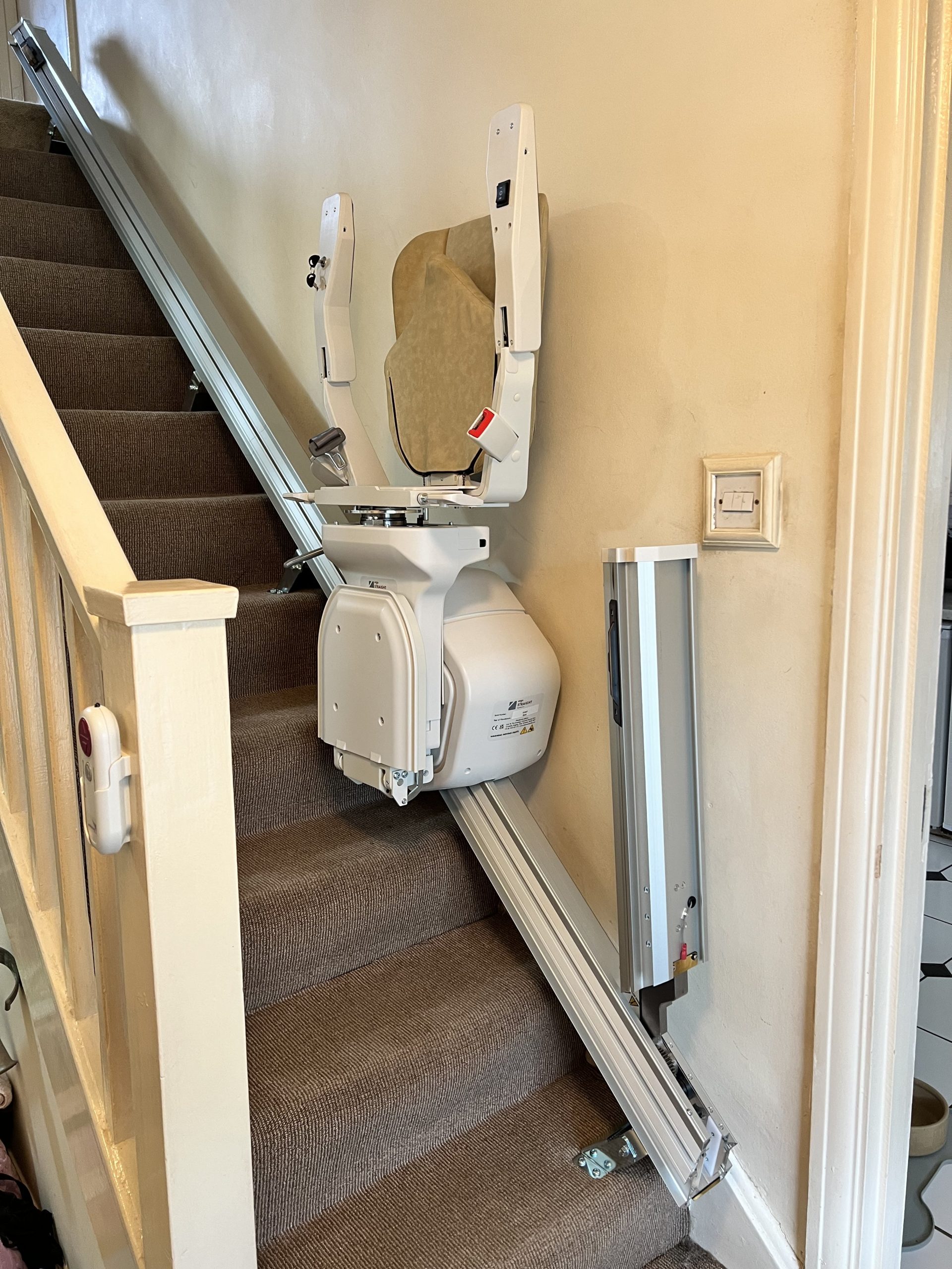 Platinum Ergo Straight straight stairlift specialist example seat folded and parked halfway up stairs powered hinge folded up not blocking door at bottom